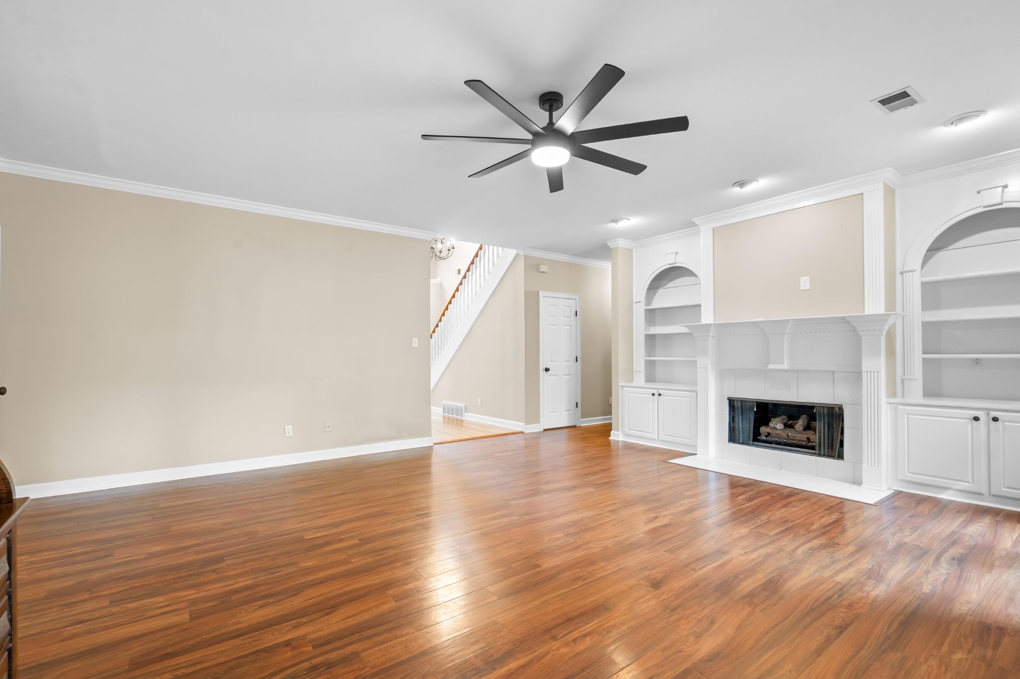 927 Oakmont Ridge Cove Collierville, TN 38017 - Photo 7 of 40 an empty room with wooden floor fireplace and windows