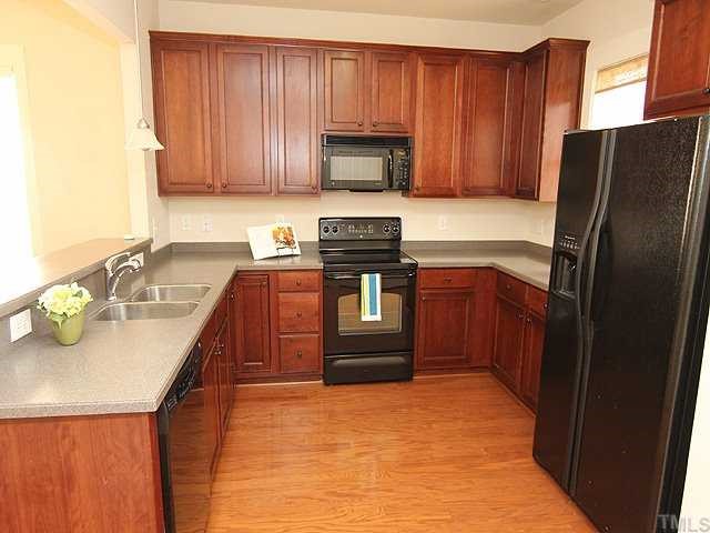 4613 All Points View Way Raleigh, NC 27614 - Photo 8 of 25 Kitchen features black appliances, smooth top range, lovely wood cabinets, and sparkling hardwood floors.
