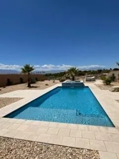a view of patio with a table and chairs under an umbrella next to a yard