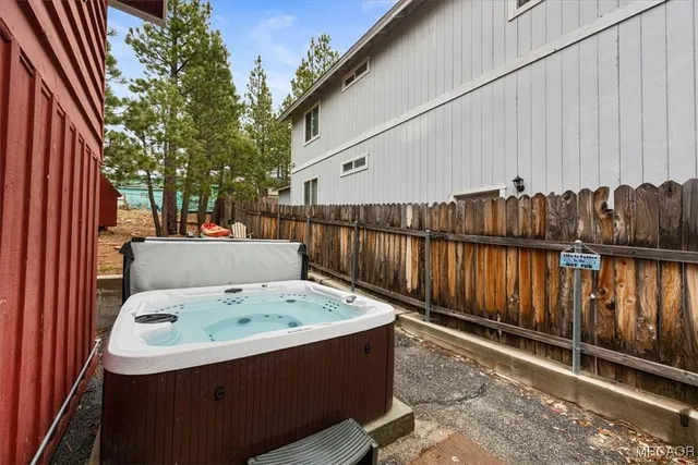 a view of a backyard with a tub and wooden fence