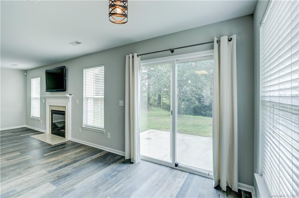 7243 Cascading Pines Drive Tega Cay, SC 29708 - Photo 13 of 33 a view of a livingroom with wooden floor and a fireplace