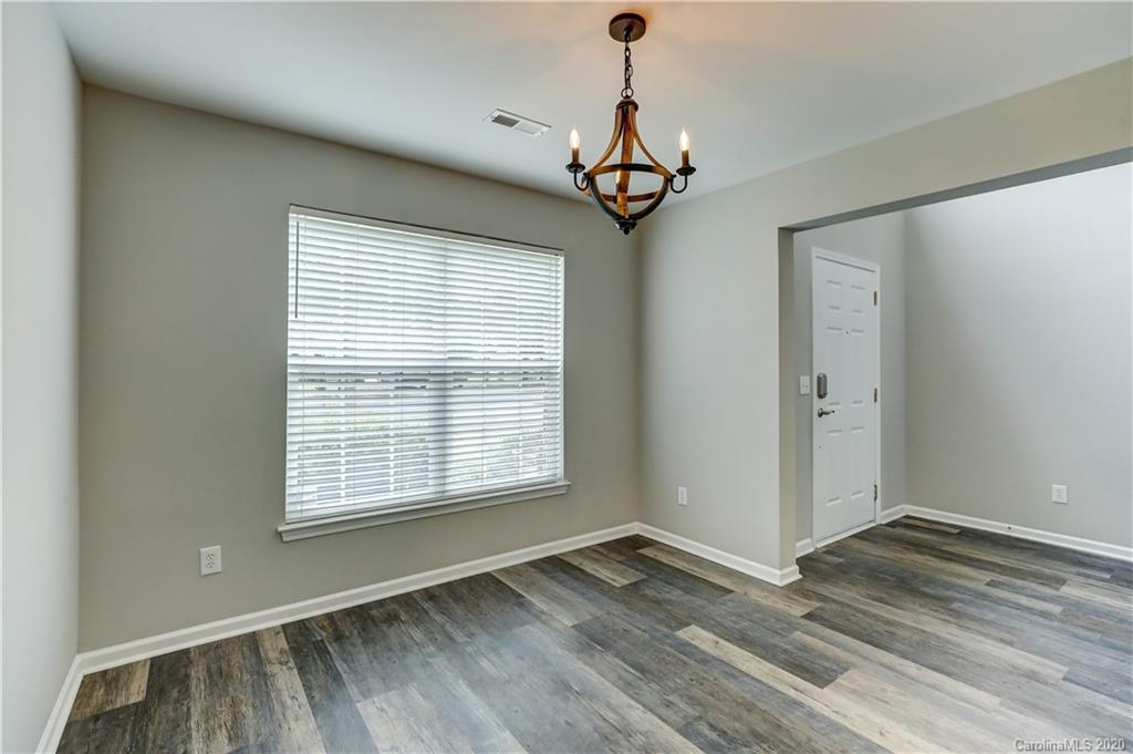 7243 Cascading Pines Drive Tega Cay, SC 29708 - Photo 4 of 33 a view of an empty room with wooden floor and a window