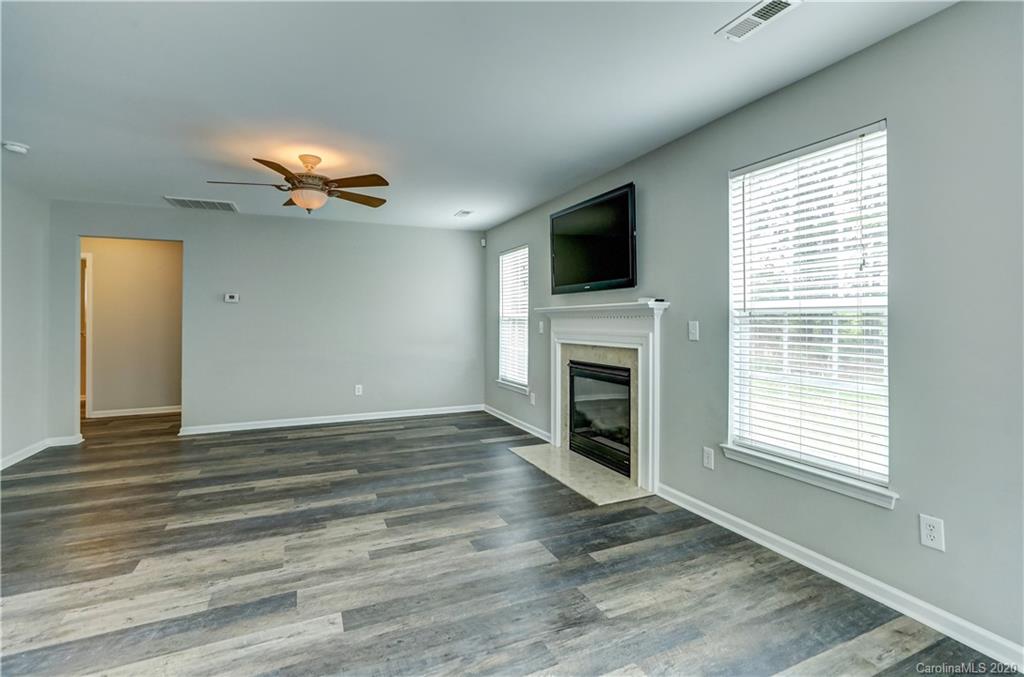 7243 Cascading Pines Drive Tega Cay, SC 29708 - Photo 7 of 33 a view of an empty room with a fireplace and a window