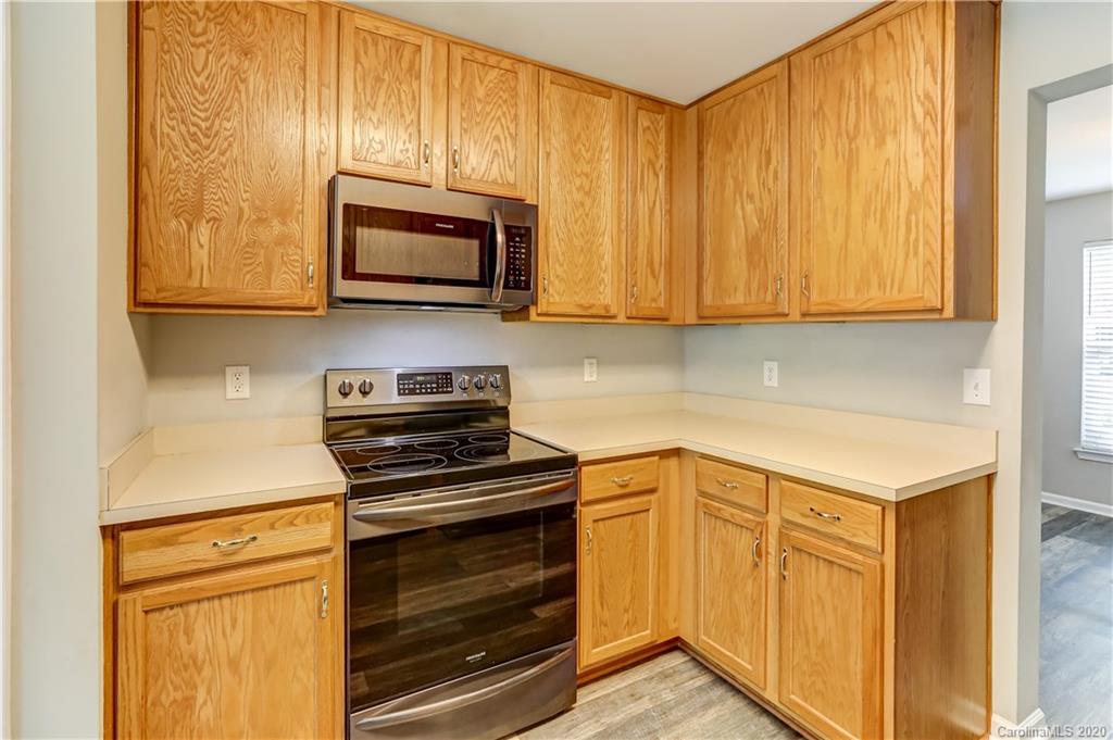 7243 Cascading Pines Drive Tega Cay, SC 29708 - Photo 9 of 33 a kitchen with stainless steel appliances granite countertop a stove microwave and cabinets