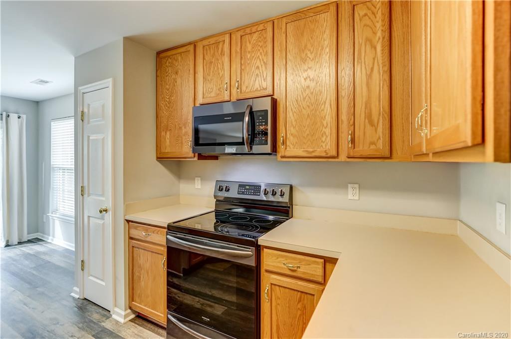 7243 Cascading Pines Drive Tega Cay, SC 29708 - Photo 10 of 33 a kitchen with stainless steel appliances wooden cabinets and a stove top oven