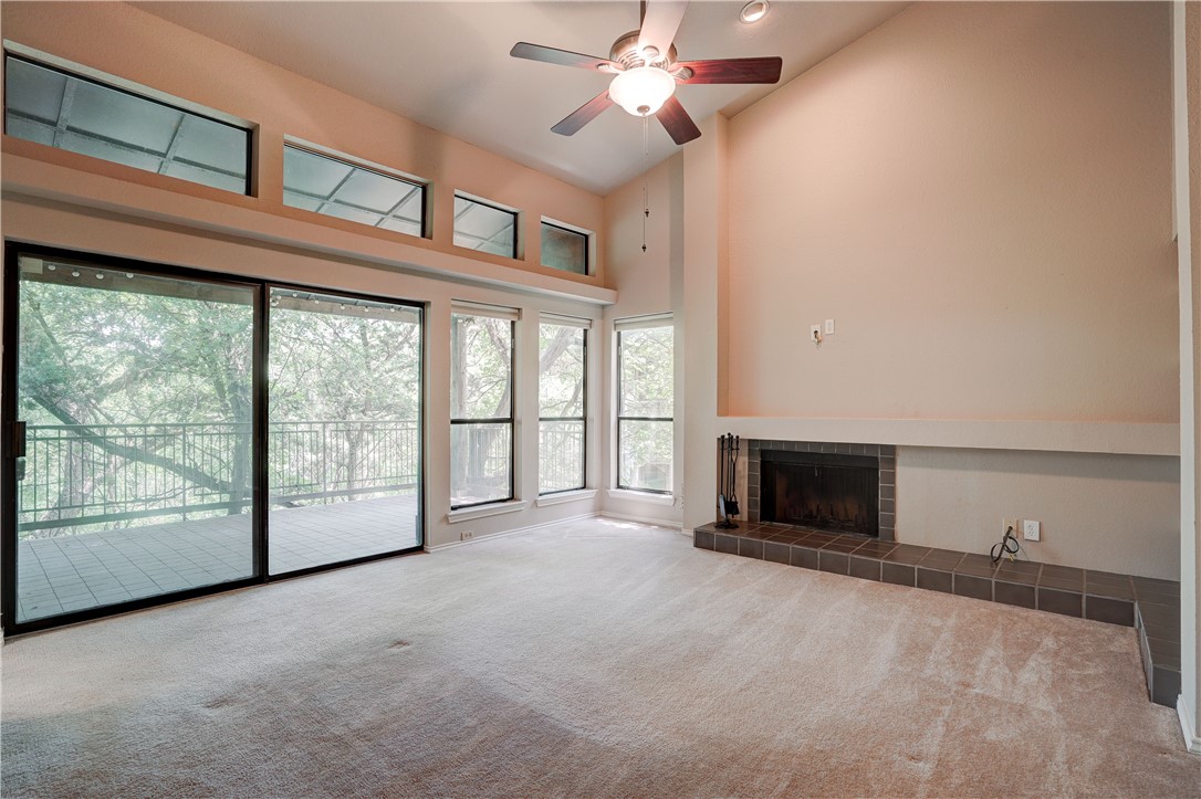 a view of an empty room with a fireplace and a window