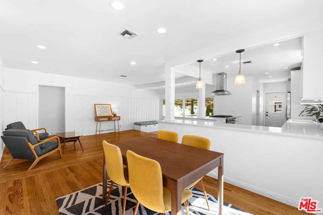 5752 Vesper Avenue Van Nuys, CA 91411 - Photo 14 of 30 a living room with stainless steel appliances kitchen island a table and chairs in it