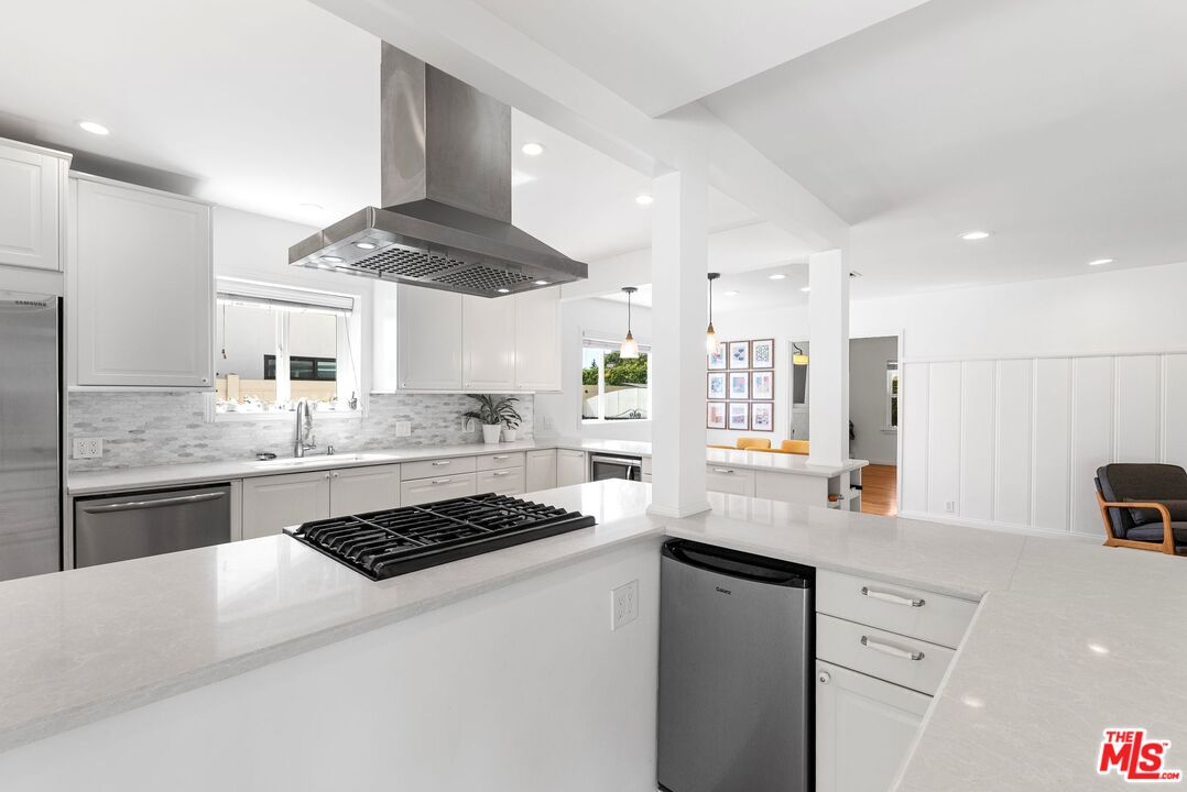 5752 Vesper Avenue Van Nuys, CA 91411 - Photo 17 of 30 a kitchen with a refrigerator a stove a sink dishwasher and white cabinets next to a window