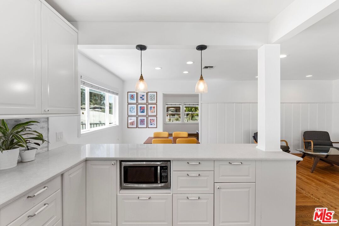 5752 Vesper Avenue Van Nuys, CA 91411 - Photo 4 of 30 a kitchen with stainless steel appliances kitchen island granite countertop a sink a stove and a window