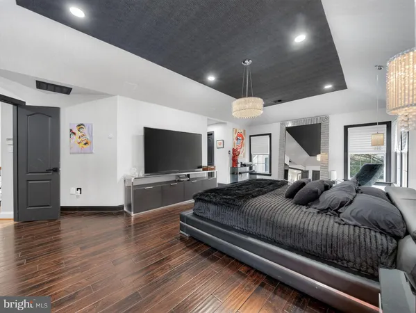 a spacious bedroom with a bed and a flat screen tv