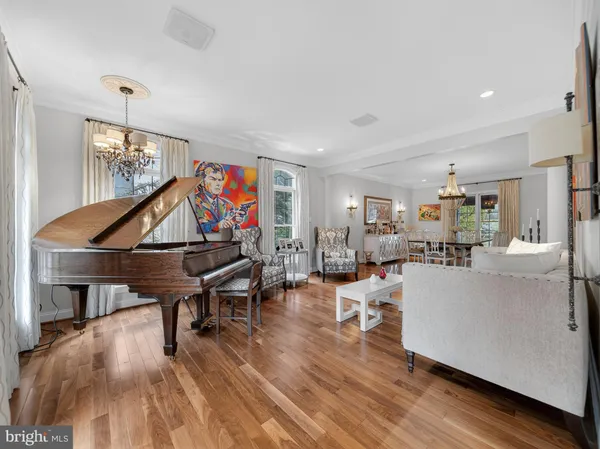 a dining room with wooden floor a chandelier fan a wooden table and chairs
