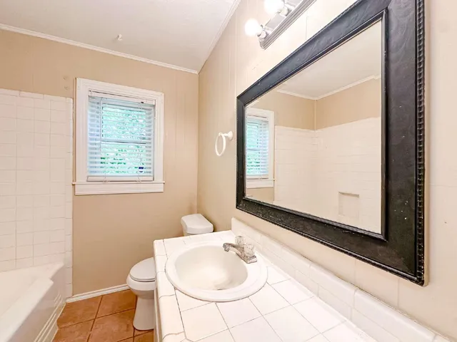 a bathroom with a sink mirror vanity and toilet