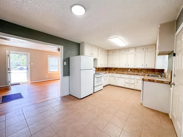 a kitchen with a refrigerator sink and cabinets