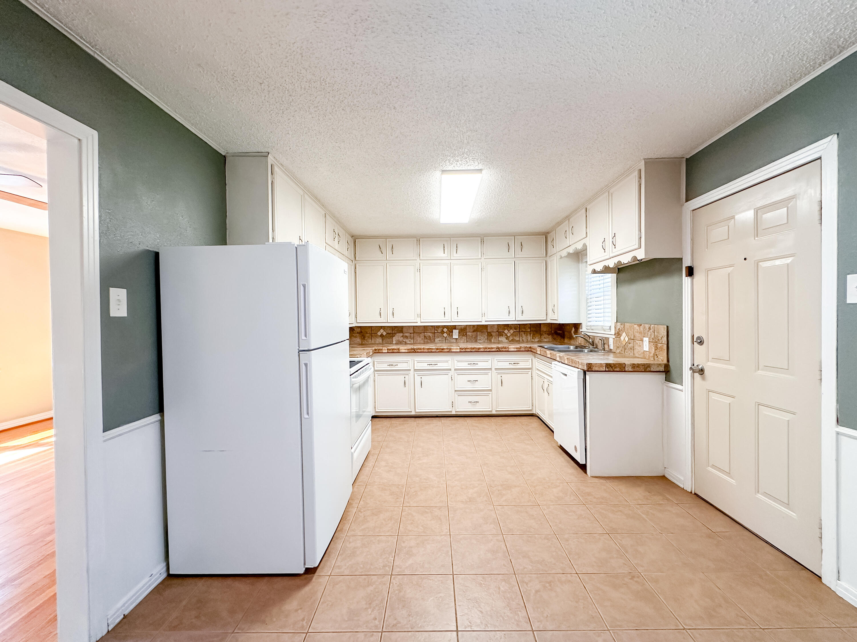 3714 26th Street Lubbock, TX 79410 - Photo 6 of 18 a kitchen with a refrigerator a sink and cabinets