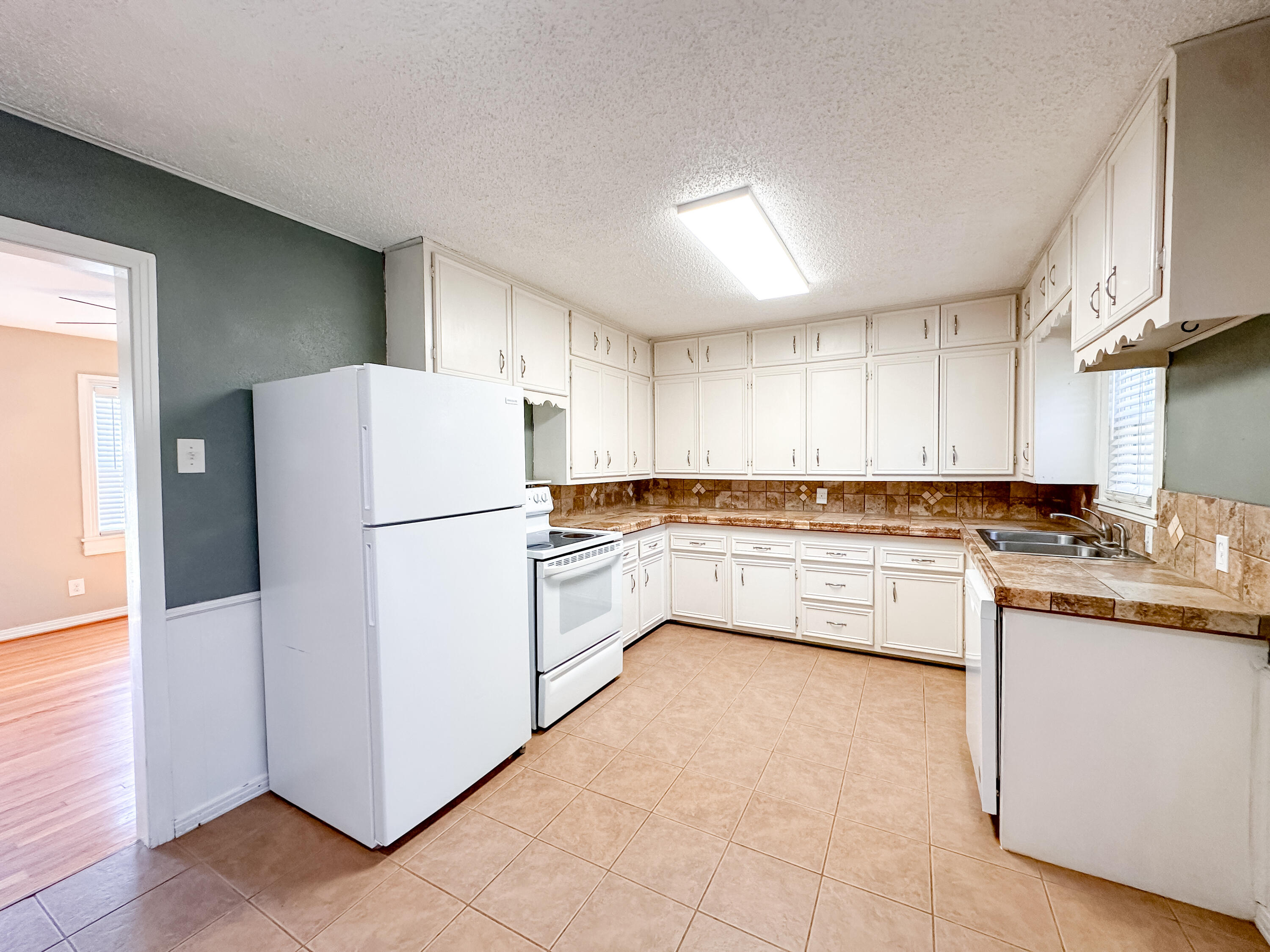 3714 26th Street Lubbock, TX 79410 - Photo 7 of 18 a kitchen with a refrigerator a sink and cabinets