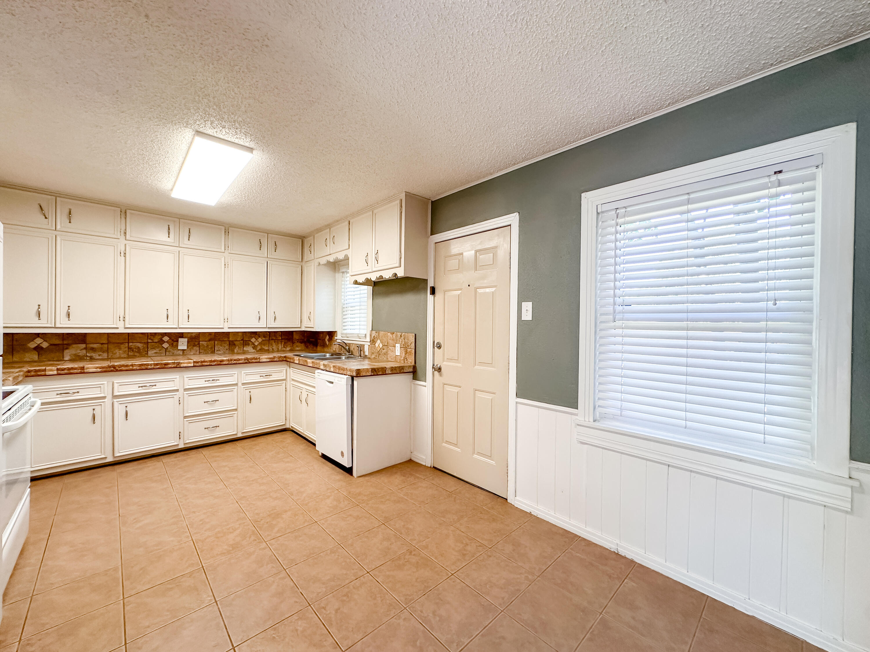 3714 26th Street Lubbock, TX 79410 - Photo 8 of 18 a large white kitchen with white cabinets and white appliances