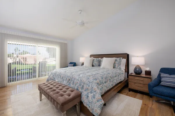 a bedroom with a bed and a couch with wooden floor