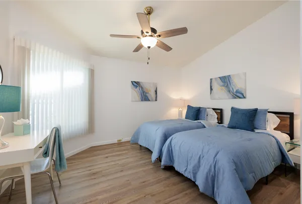 a bedroom with bed and wooden floor