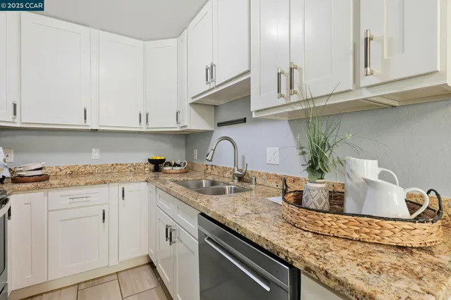 a kitchen with granite countertop white cabinets and white appliances