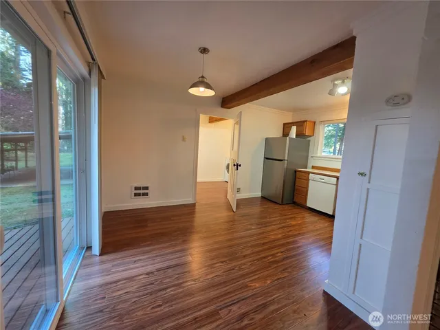 a kitchen with a refrigerator and wooden floor