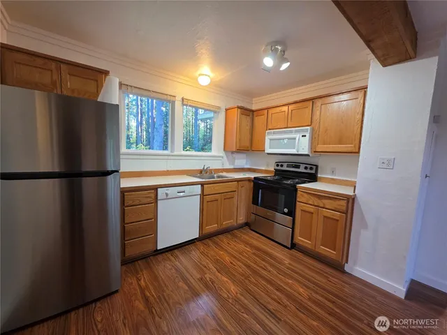a kitchen with stainless steel appliances granite countertop a stove a sink and a refrigerator