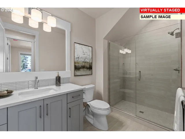 a bathroom with a shower sink vanity mirror and toilet