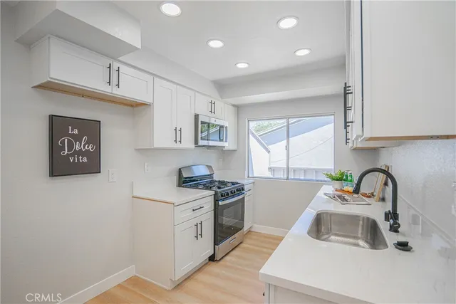 a kitchen with sink a stove and cabinets