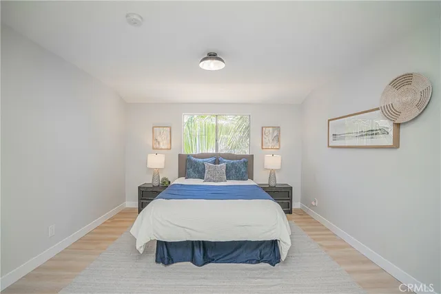 a bedroom with a large bed and wooden floor
