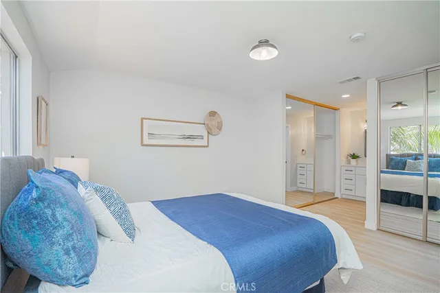 a bedroom with a large bed and glass door