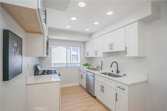 a kitchen with sink a stove and cabinets