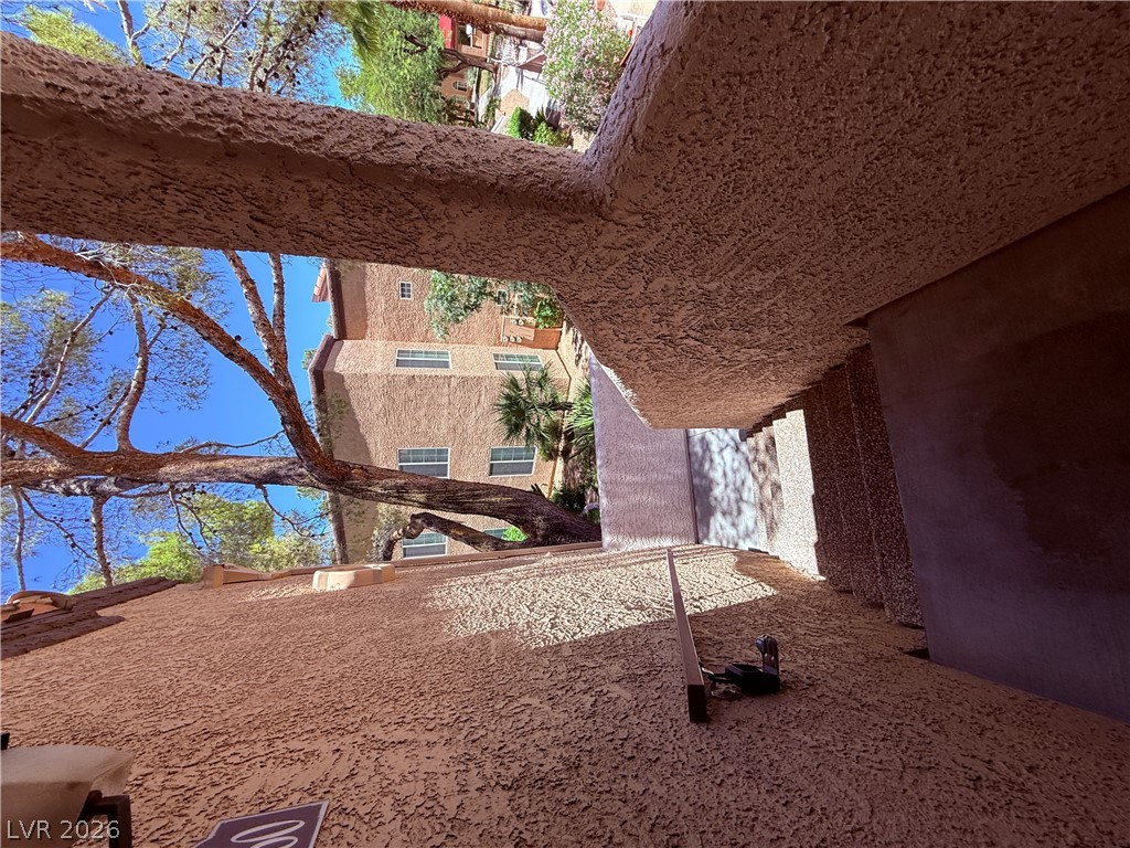 9325 West Desert Inn Road, Unit 260 Las Vegas, NV 89117 - Photo 35 of 42 Textured facade and abundant tree cover frame the outdoor staircase leading to private entries.