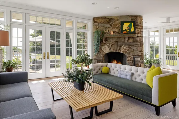 a living room with furniture a large window and a fireplace