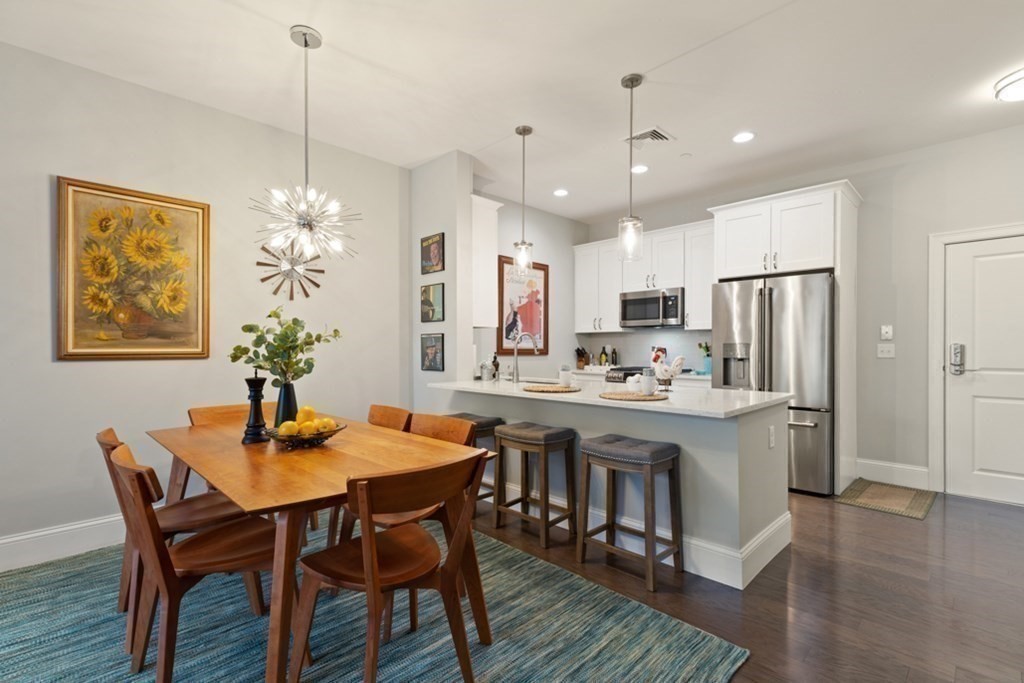 8 Sanborn Street, Unit 1009 Reading, MA 01867 - Photo 12 of 30 a kitchen with stainless steel appliances granite countertop a dining table chairs and white cabinets