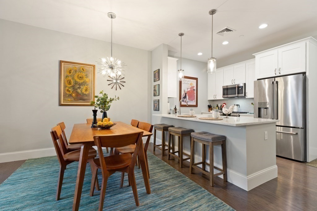 8 Sanborn Street, Unit 1009 Reading, MA 01867 - Photo 13 of 30 a kitchen with stainless steel appliances granite countertop a dining table chairs and granite counter tops