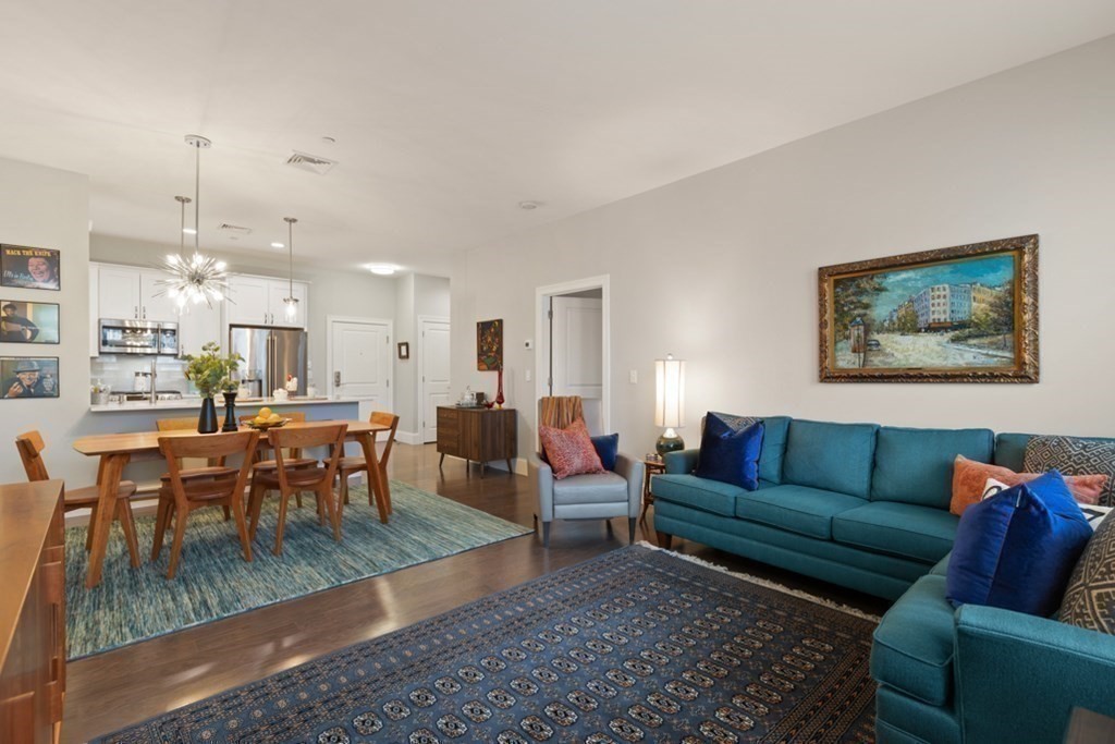 8 Sanborn Street, Unit 1009 Reading, MA 01867 - Photo 15 of 30 a living room with furniture kitchen view and a dining table