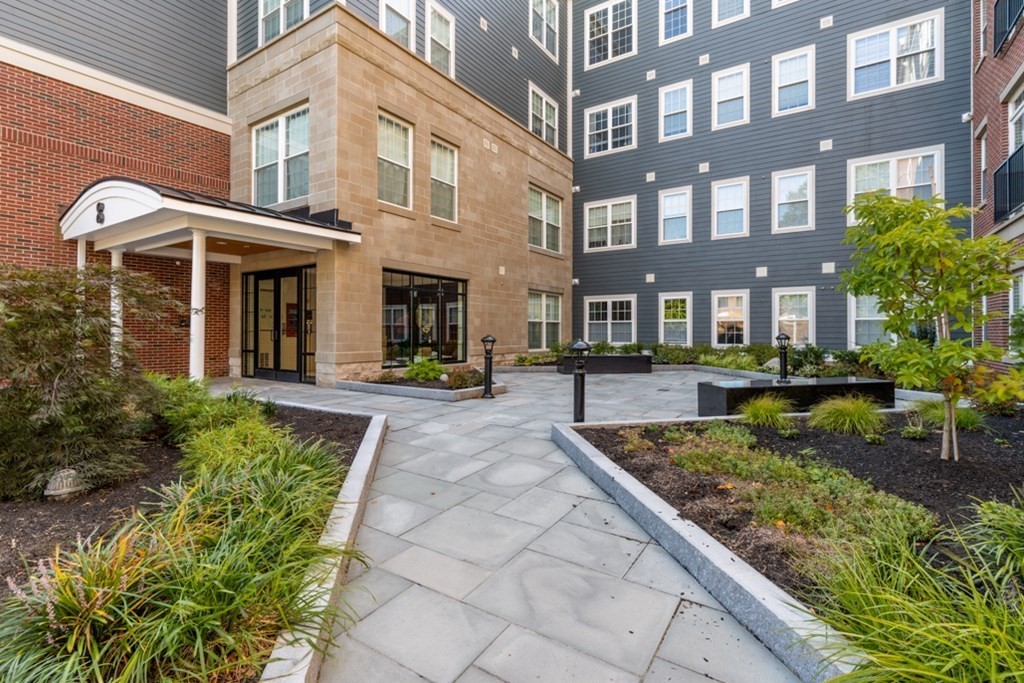 8 Sanborn Street, Unit 1009 Reading, MA 01867 - Photo 2 of 30 a front view of a building with a garden