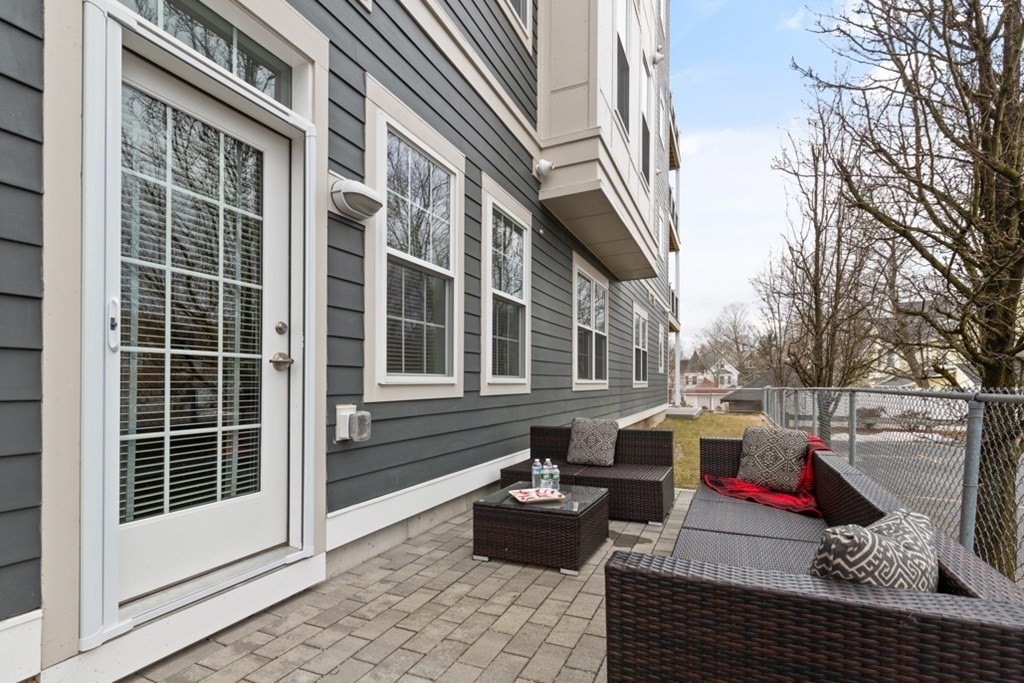 8 Sanborn Street, Unit 1009 Reading, MA 01867 - Photo 24 of 30 a view of a patio with couches chairs and wooden floor