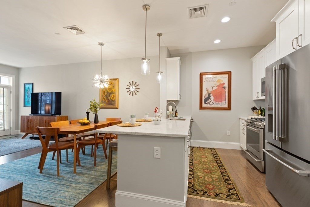 8 Sanborn Street, Unit 1009 Reading, MA 01867 - Photo 6 of 30 a kitchen with stainless steel appliances granite countertop a sink a stove a refrigerator and island