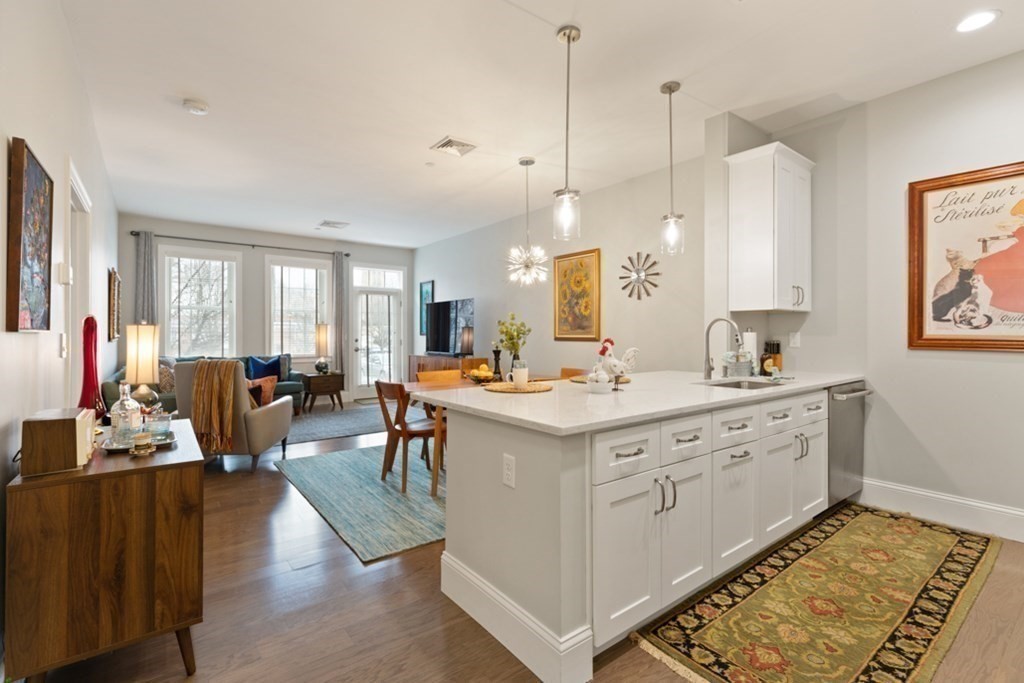 8 Sanborn Street, Unit 1009 Reading, MA 01867 - Photo 7 of 30 a large kitchen with lots of counter space and painting on the wall