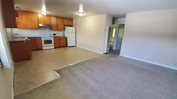 a view of a kitchen with a sink and a refrigerator
