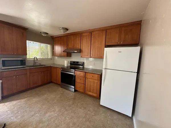 a kitchen with sink a refrigerator and cabinets
