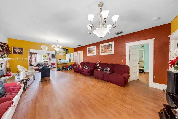 a living room with furniture chandelier and a wooden floor
