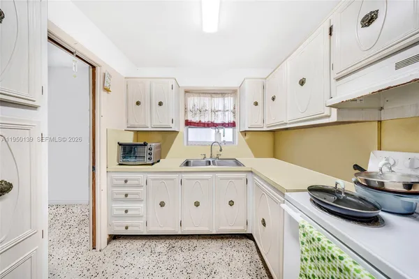 a kitchen with granite countertop a sink stove and cabinets