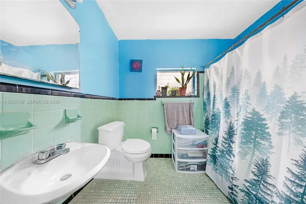 a bathroom with a toilet sink and mirror