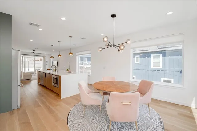 a dining room with furniture a chandelier and wooden floor