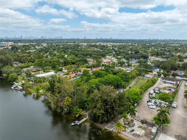 an aerial view of residential houses with outdoor space and trees