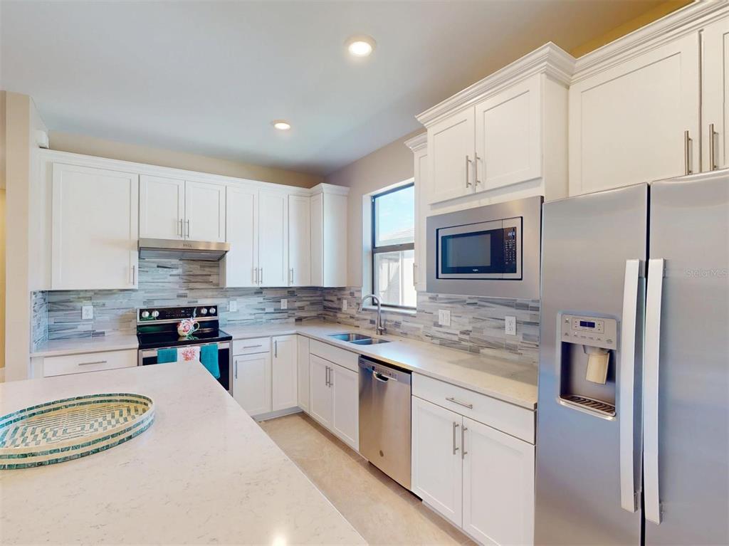 1352 Raspberry Dr Port North Port, FL 34289 - Photo 20 of 88 a kitchen with stainless steel appliances granite countertop a stove sink and cabinets