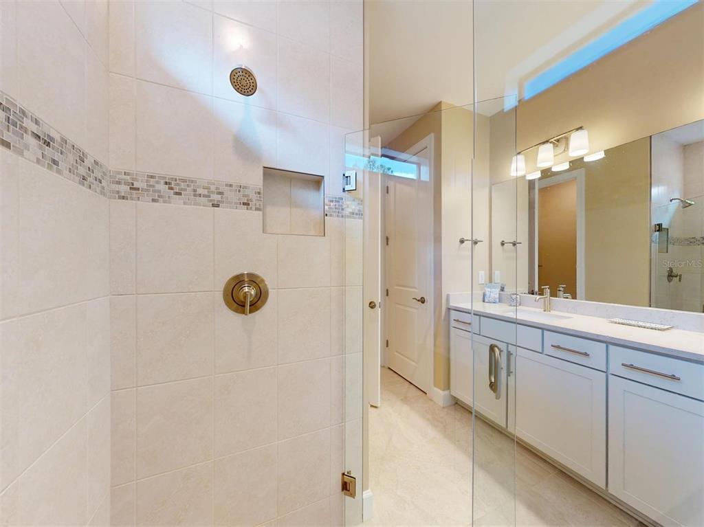 1352 Raspberry Dr Port North Port, FL 34289 - Photo 40 of 88 a bathroom with a double vanity sink a large mirror a shower and a bathtub