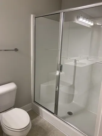 a white toilet sitting next to a shower