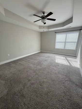 an empty room with a ceiling fan and window